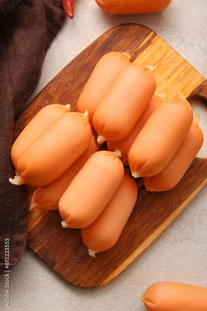 Board of tasty boiled sausages on grey background