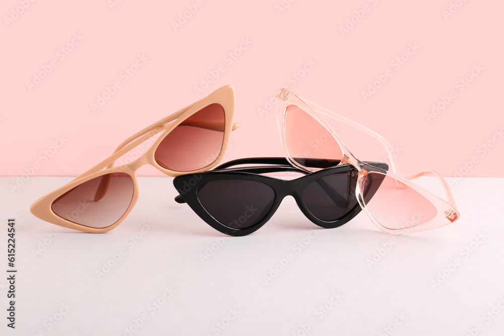 Stylish sunglasses on color background