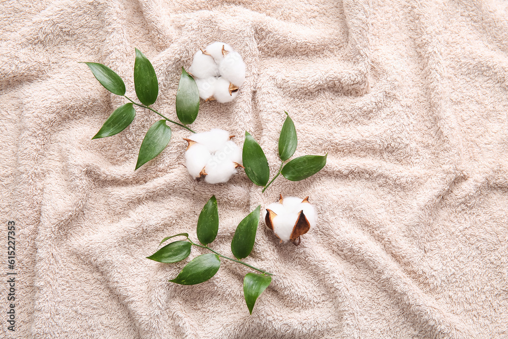 Cotton flowers and plant twigs on beige blanket