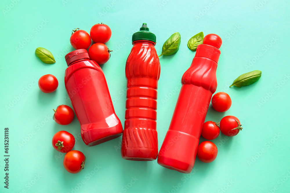 Bottles of ketchup and tomatoes on blue background