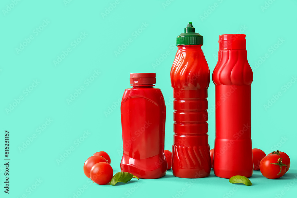 Bottles of ketchup and tomatoes on blue background