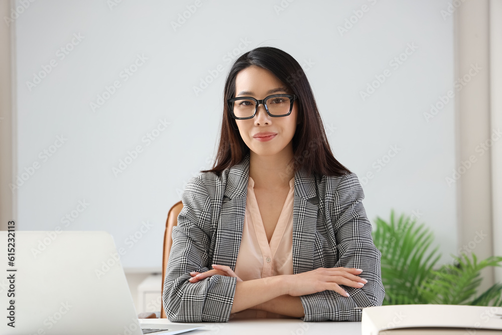 Beautiful Asian businesswoman in stylish eyeglasses in office