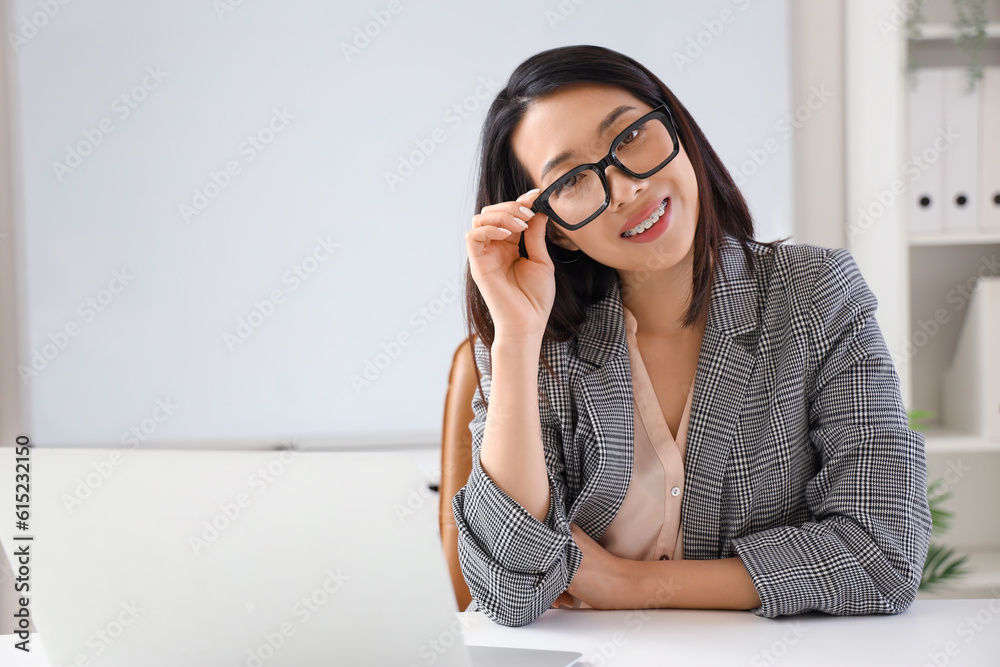 Beautiful Asian businesswoman in stylish eyeglasses in office