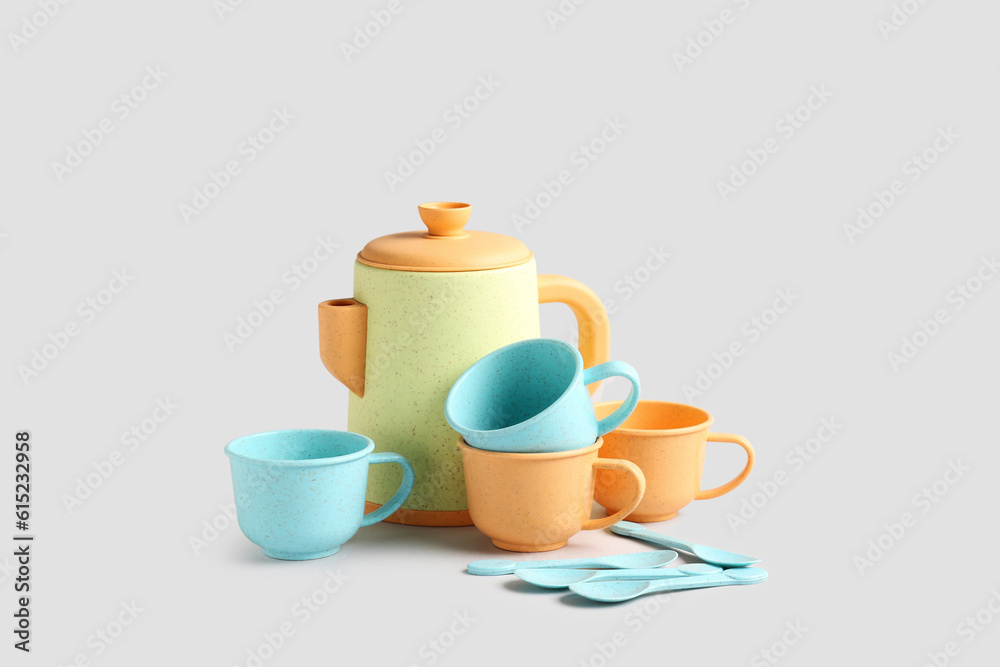 Teapot with cups and spoons on grey background. Childrens Day celebration