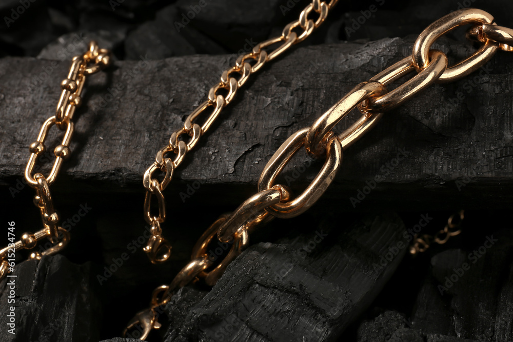 Beautiful chain bracelets on black charcoal, closeup