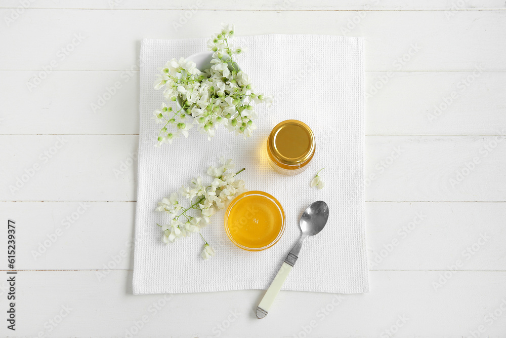 Composition with sweet honey and acacia flowers on light wooden background