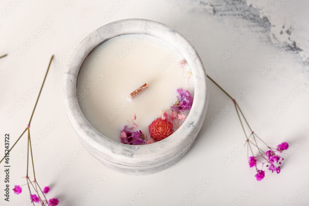 Holder with candle and flowers on white background