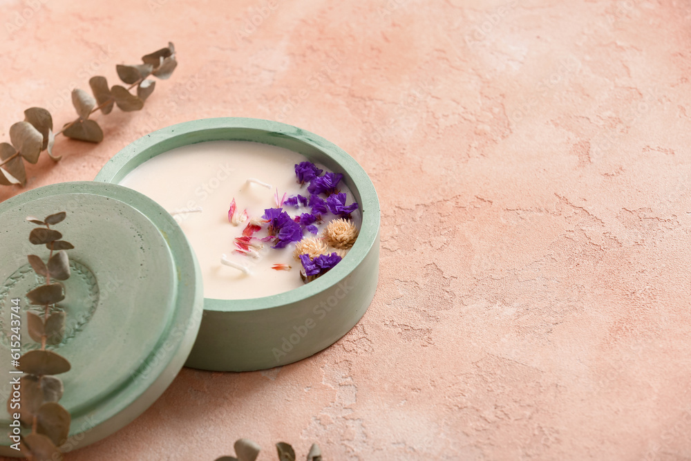 Holder with candle and eucalyptus on pink background