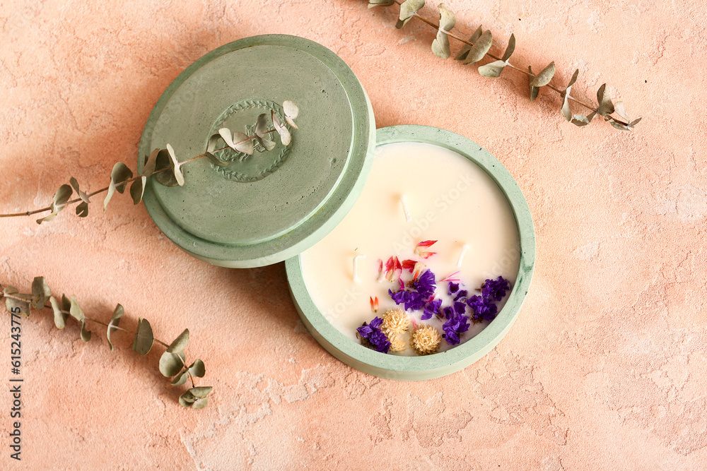 Holder with candle and eucalyptus on pink background