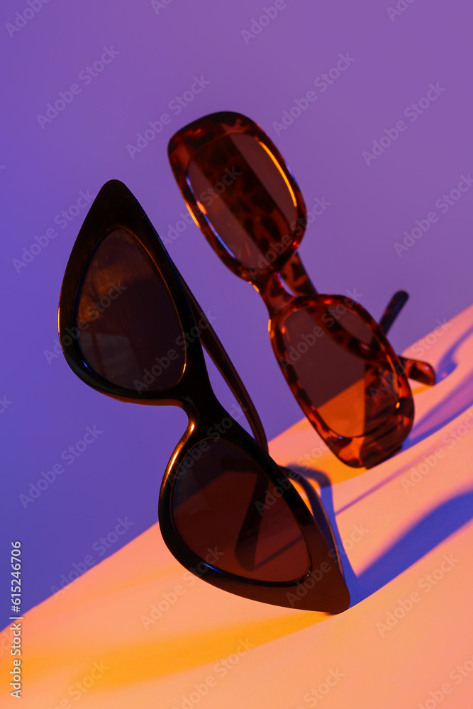 Different stylish sunglasses on colorful background