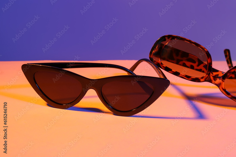 Different stylish sunglasses on colorful background