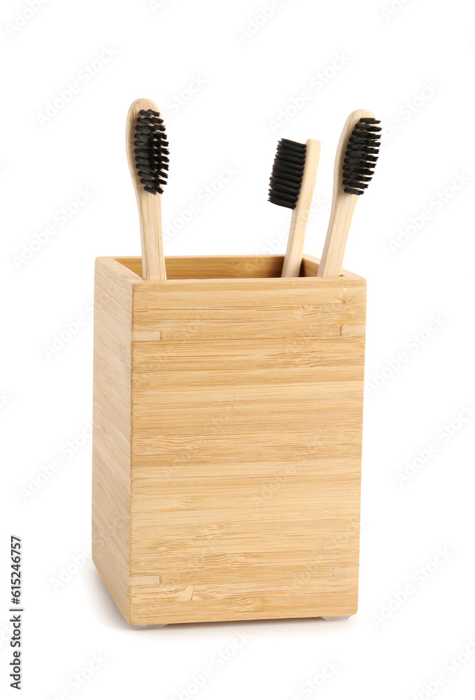 Bamboo tooth brushes in holder on white background