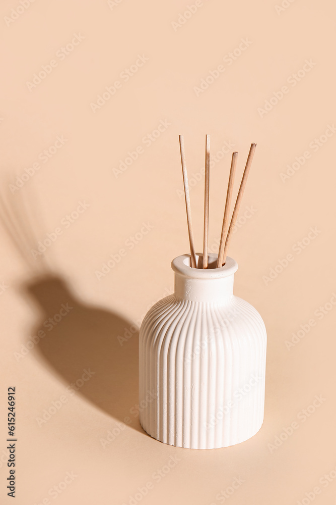 Bottle of reed diffuser on beige background