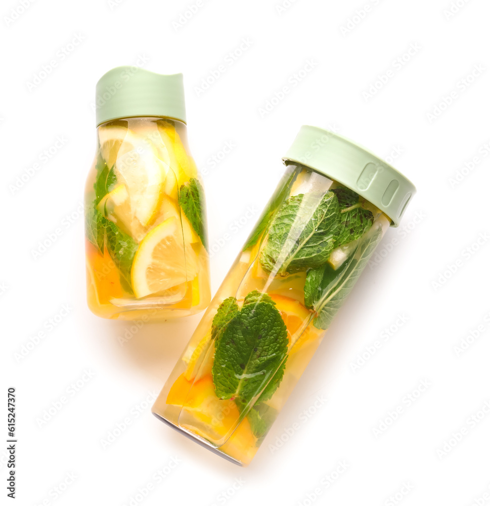 Sports bottles of infused water with lemon and mint on white background