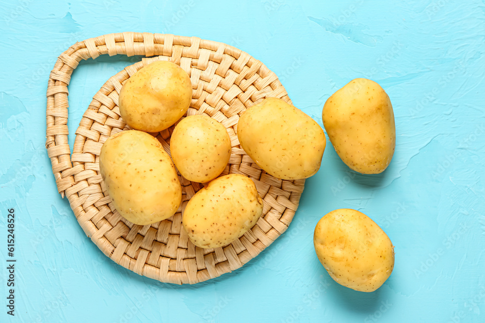 Raw baby potatoes on blue background