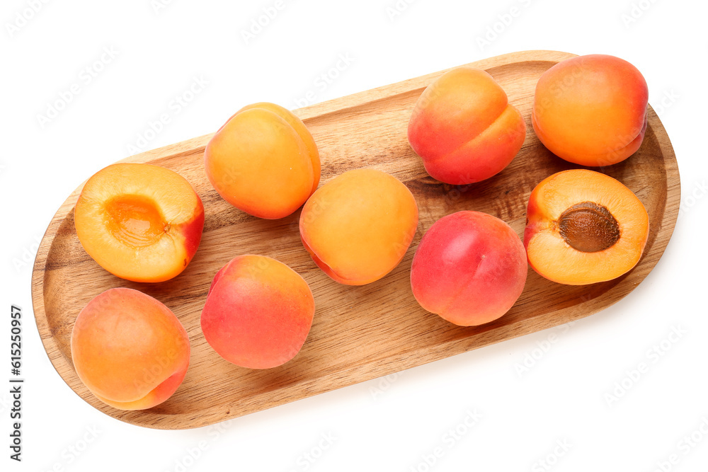 Wooden board with ripe apricots isolated on white background