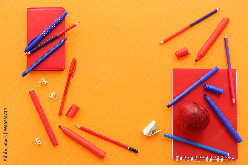 Fresh red apple with different stationery on orange background