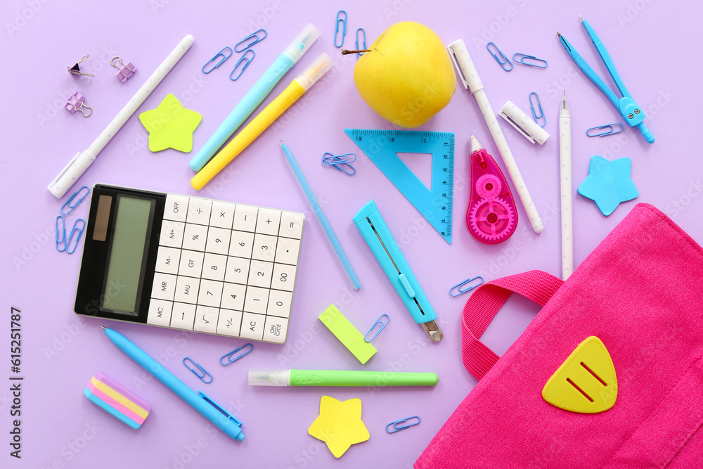 Backpack with fresh apple, calculator and different stationery on lilac background