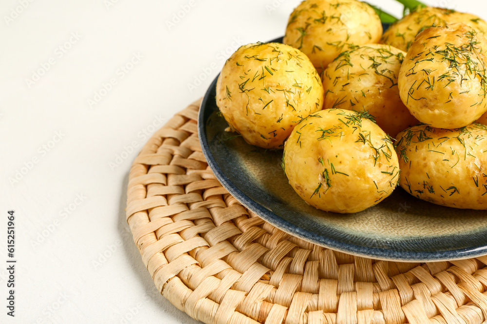 Plate of boiled baby potatoes with dill on white background