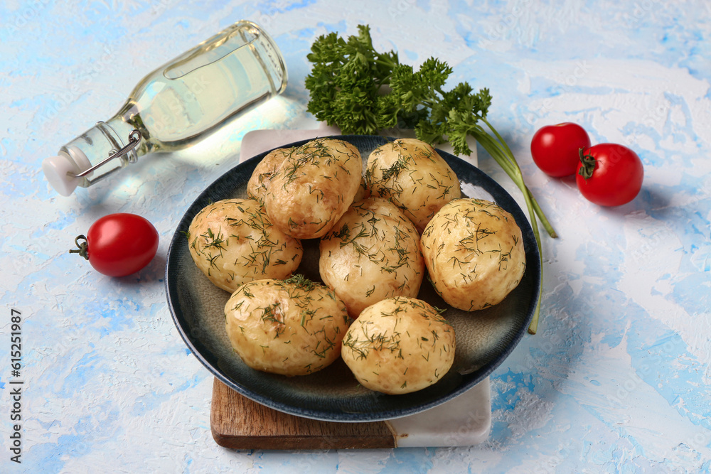 Plate of boiled baby potatoes with dill and parsley on blue background