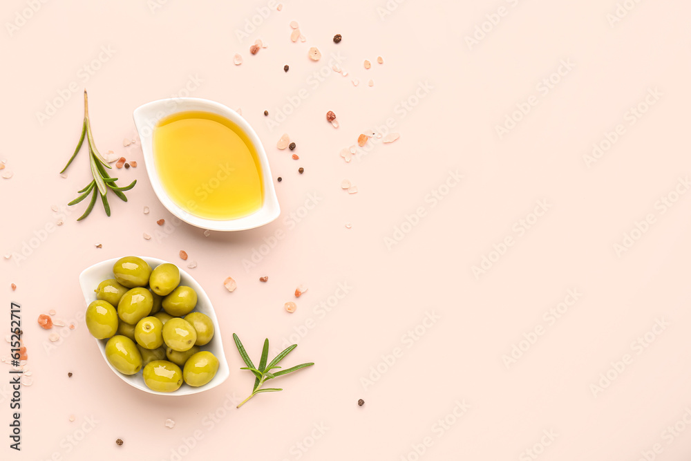 Bowls with ripe olives and oil on pink background