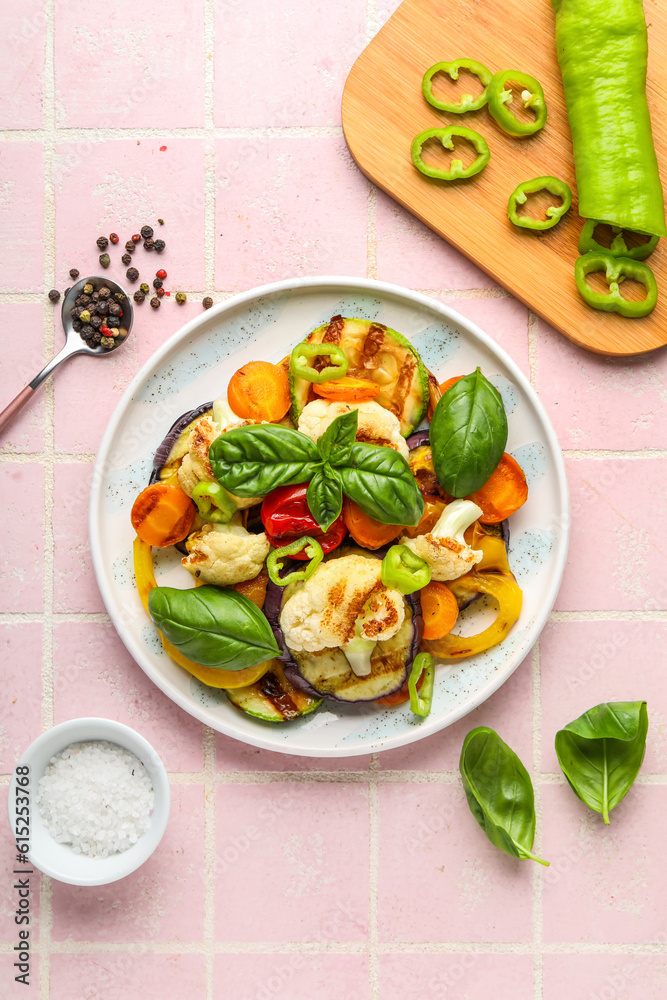 Plate of grilled vegetables on pink tile background