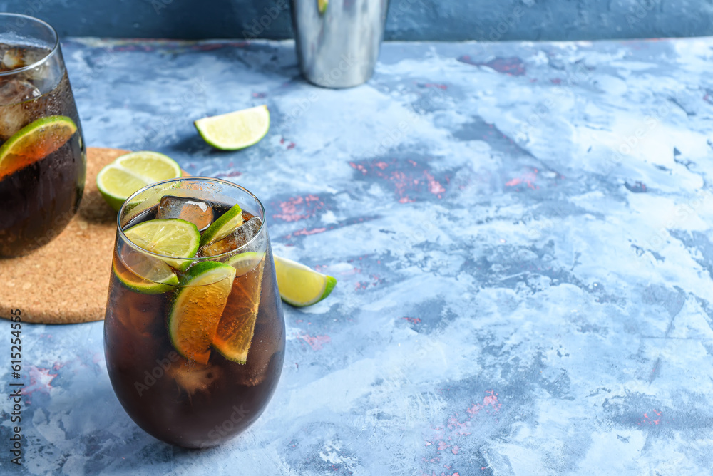 Glasses of cold Cuba Libre cocktail on blue background