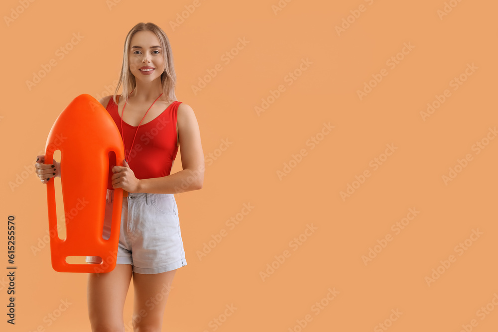 Female lifeguard with rescue buoy on beige background