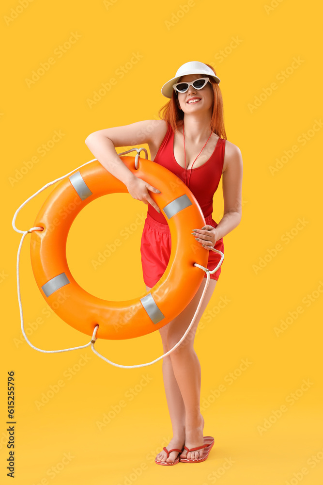 Female lifeguard with ring buoy on yellow background