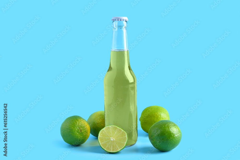 Bottle of cold beer with lime on blue background