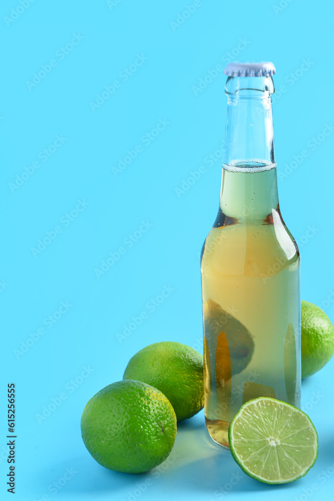 Bottle of cold beer with lime on blue background