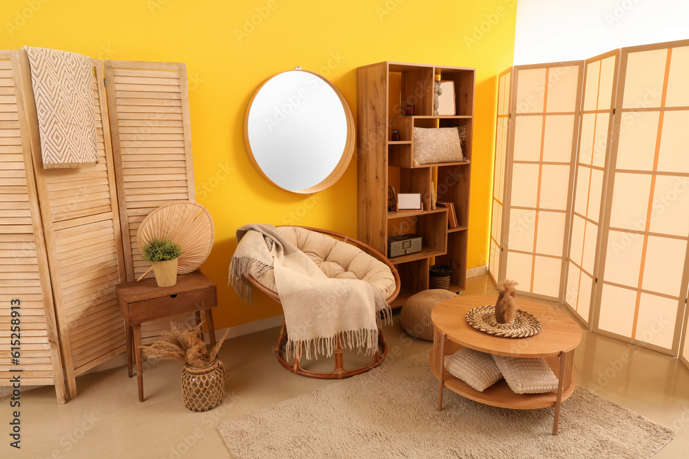 Interior of living room with armchair, shelving unit and mirror