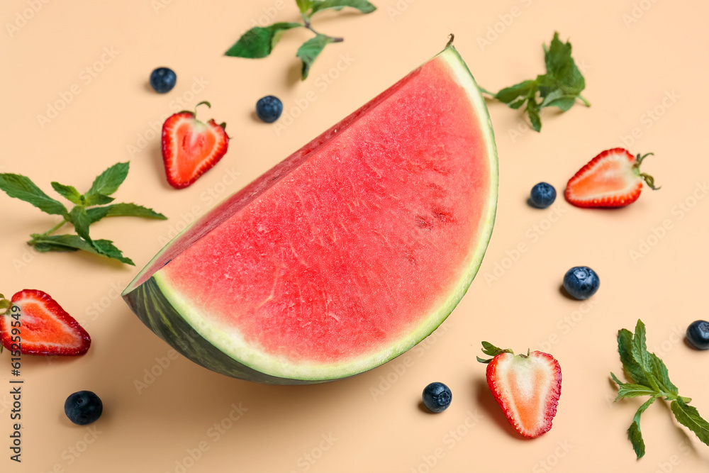 Piece of fresh watermelon and different berries on orange background