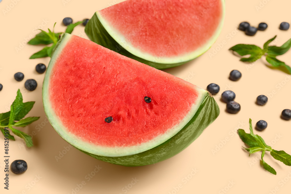 Pieces of fresh watermelon and blueberries on orange background