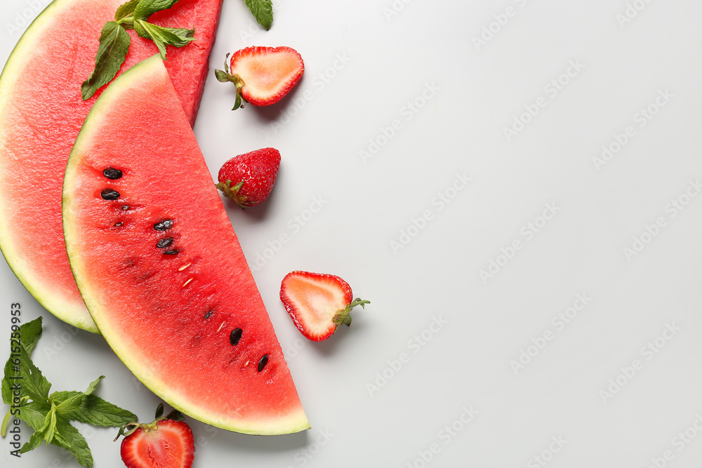 Pieces of fresh watermelon and strawberries on grey background