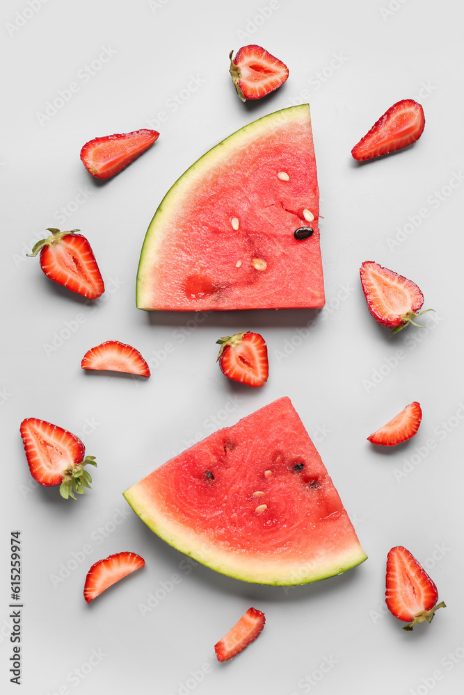 Pieces of fresh watermelon and strawberries on grey background