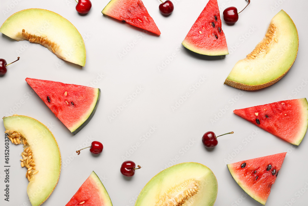 Frame made of pieces of fresh watermelon and different berries on grey background