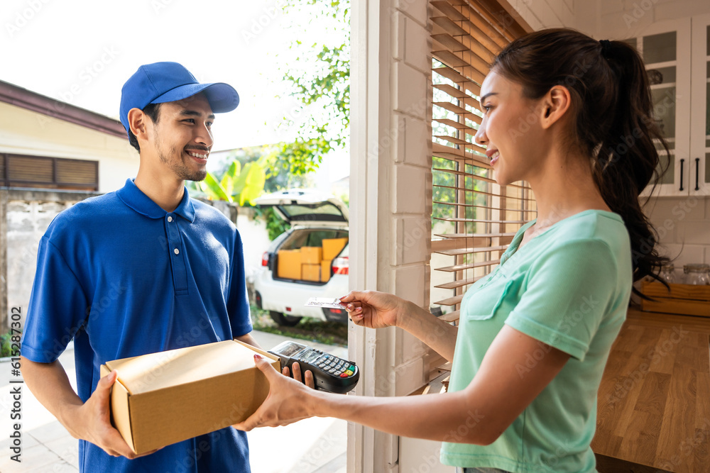 Asian young delivery man delivering package to female customer at home. 