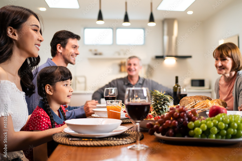 Multi-ethnic big family having dinner, enjoy evening party in house. 