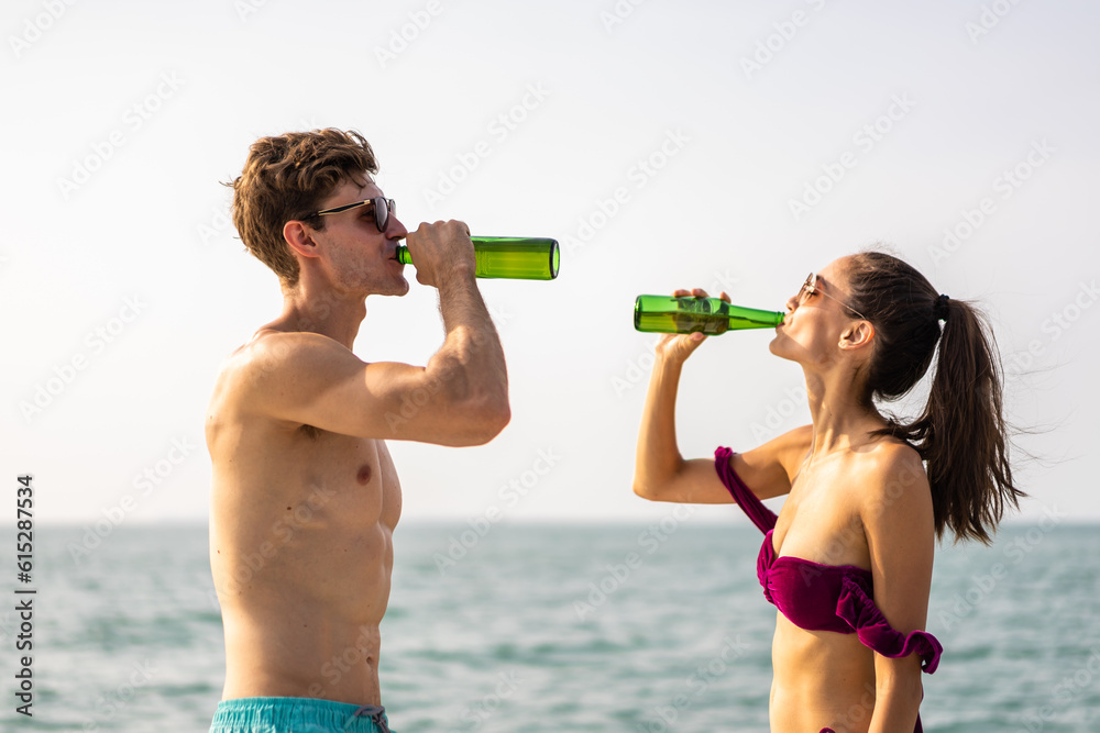 Caucasian young couple drink a bottle of beer, having party in yacht. 