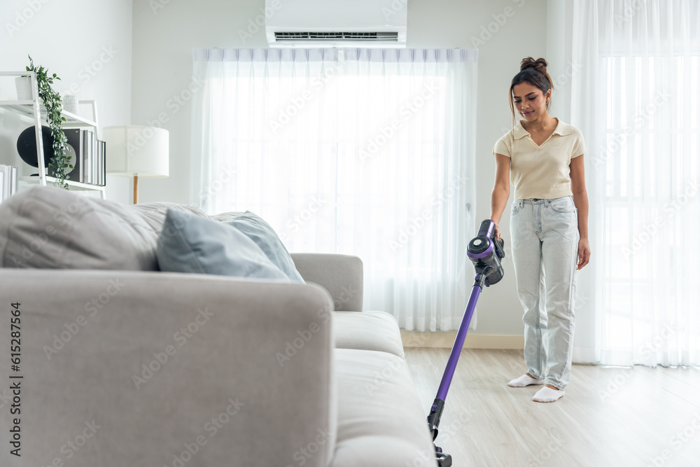 Asian young beautiful woman cleaning indoors in living room at home. 