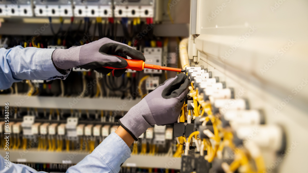 Electricians work to connect electric wires in the system, switchboard, electrical system in Control