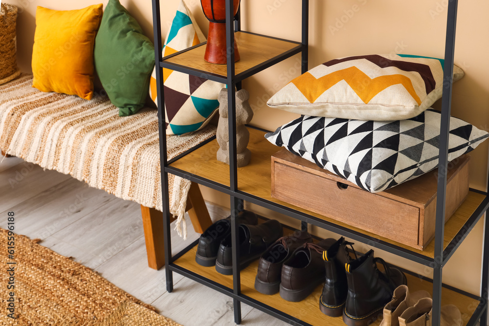 Shelving unit with pillows and shoes in hall