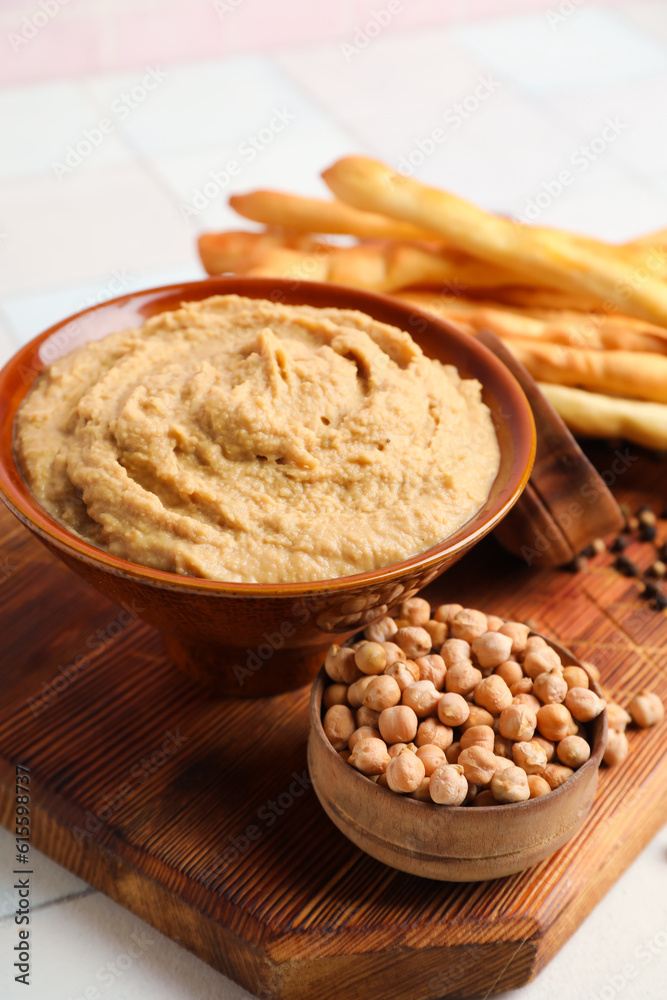 Bowl with tasty hummus on table