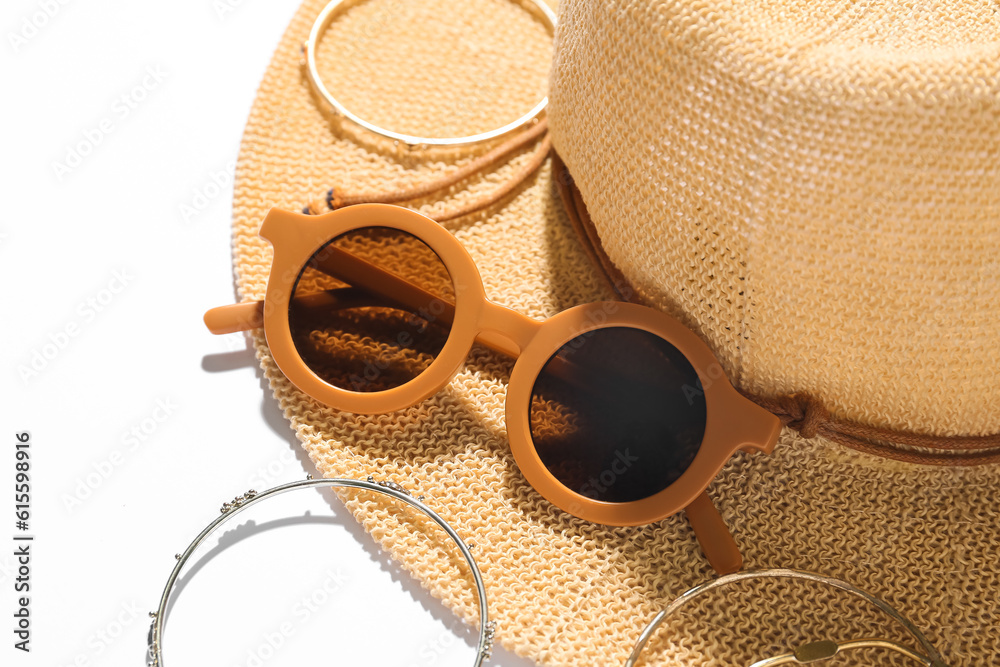 Jewelry with sunglasses and summer hat on white background, closeup