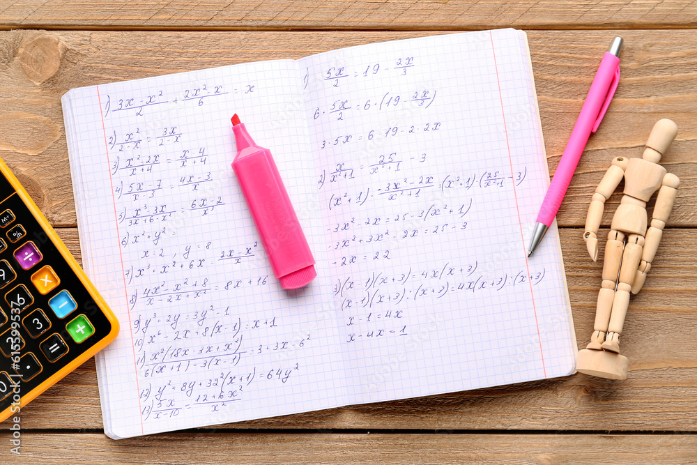 Copybook with maths formulas, calculator, mannequin and pens on wooden background