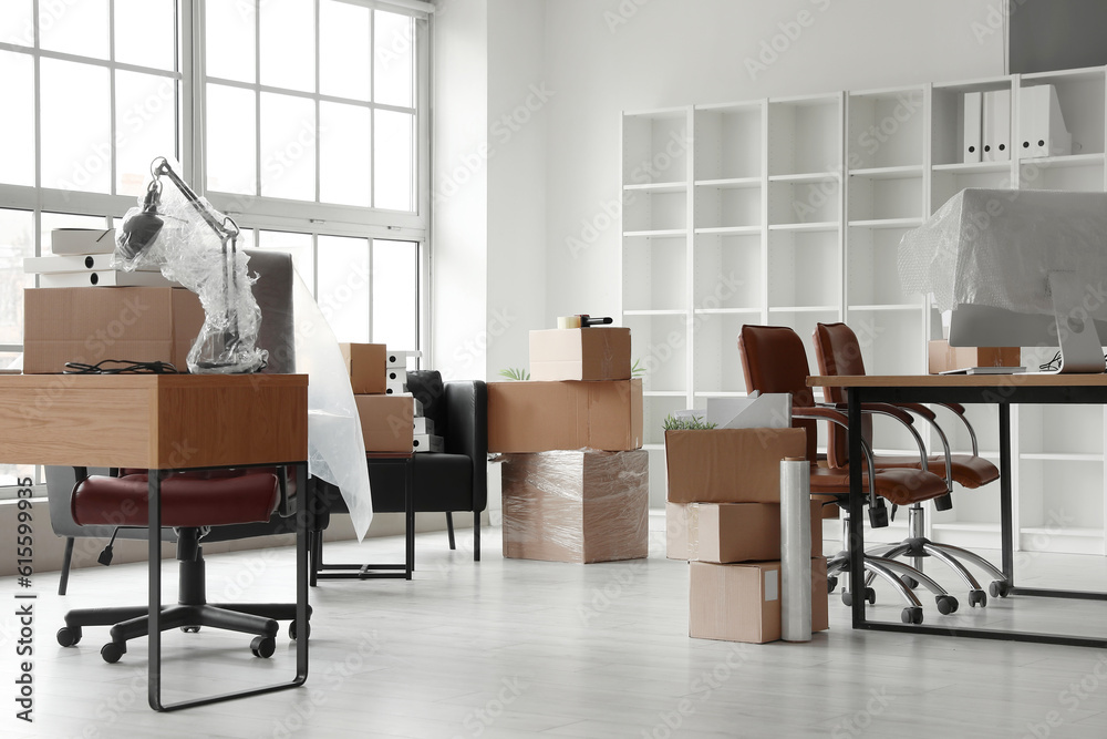 Workplaces with cardboard boxes in office on moving day