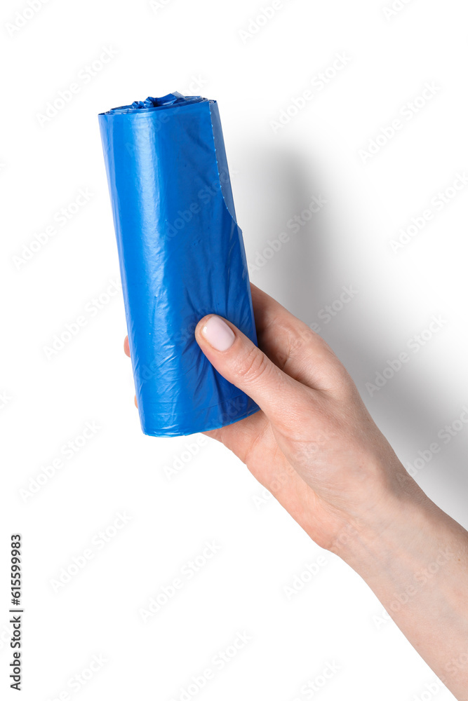 Female hand holding roll of garbage bags on white background