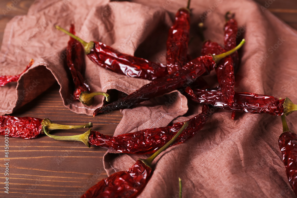 Dry hot chili peppers on brown wooden background