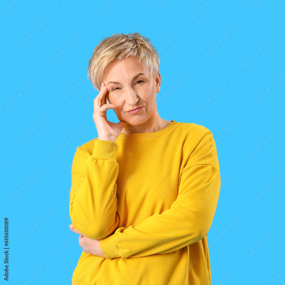 Thoughtful mature woman on blue background